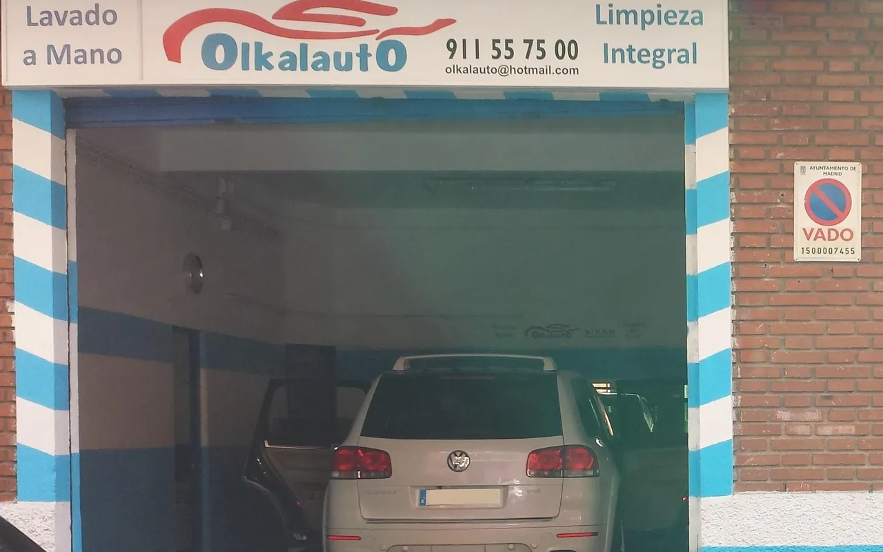 La nave de lavado a mano por dentro, con un coche blanco y el rótulo «Lavado a mano» encima de la puerta